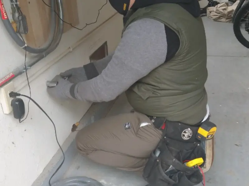 Electrician performing outlet wiring in a Greenbrier garage